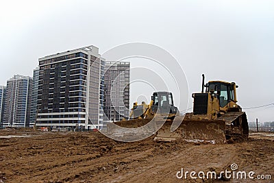 Group of dozers with buckets at construction site. Bulldozer during land clearing, grading, pool excavation, utility trenching and Stock Photo