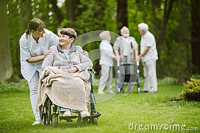 Elder people and nurse taking care of them Stock Photo