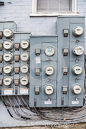 group of electric meters of an apartment building hang on a brick wall. Close-up Editorial Stock Photo
