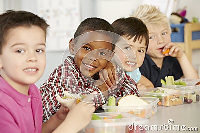 Group Of Elementary Age Schoolchildren Eating Healthy Packed Lunch In Class Stock Photo