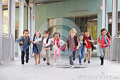 Group of elementary school kids running in a school corridor Stock Photo