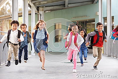 Group of elementary school kids running in a school corridor Stock Photo