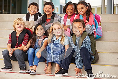 A group of elementary school kids sitting on school steps Stock Photo