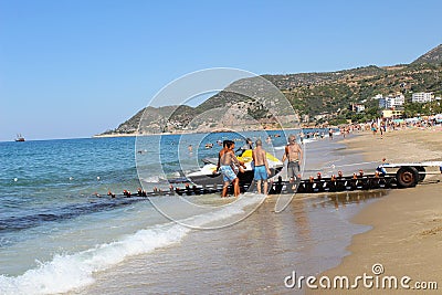 A group of employees of the water sports center descends the jet ski onto the water using a special device Editorial Stock Photo