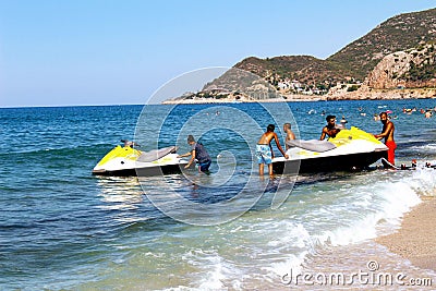 A group of employees of the water sports center descends the jet ski onto the water using a special device Editorial Stock Photo