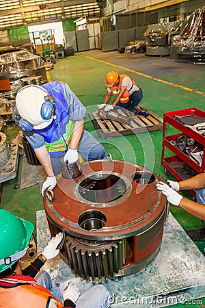 A group of engineer are repair the large engine gear wheels Editorial Stock Photo