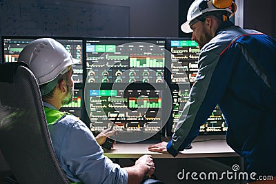 Group of engineers following production line using computer screens with Industry 4.0. Couple of factory operators controll assemb Stock Photo