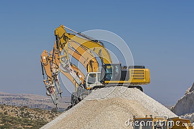 Group of excavators on gravel hill Stock Photo