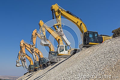 Group of excavators on gravel hill Stock Photo