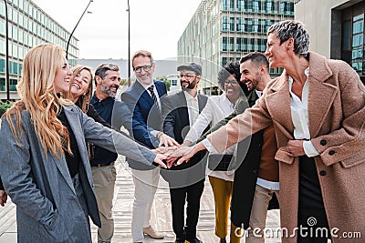 Group of excited business people stacking hands to celebrate a success or achievement. Corporate team work cooperation Stock Photo
