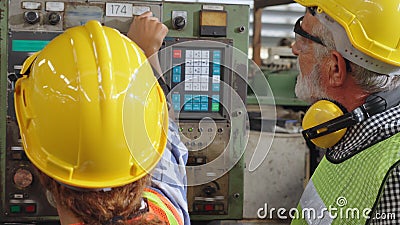 Group of factory workers using machine equipment in factory workshop Stock Photo