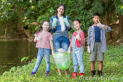 Group family asian children collecting garbage and plastic on the river to dumped into the trash for volunteer charity save enviro Stock Photo