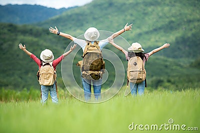Group family children travel nature trips raise arms and standing see mountain outdoors, Stock Photo