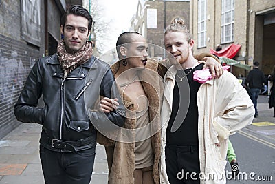 A group of fashionably dressed men posing on background of the c Editorial Stock Photo