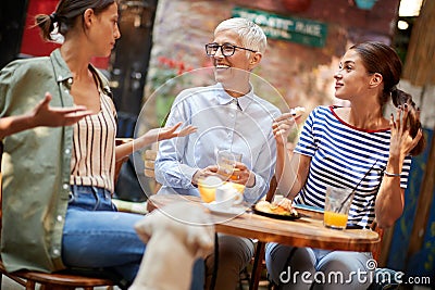 A group of female friends of different generations talking in the bar. Leisure, bar, friendship, outdoor Stock Photo