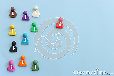 group of figures going in one direction and a unique person heading in a different direction Stock Photo