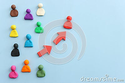 group of figures going in one direction and a unique person heading in a different direction Stock Photo