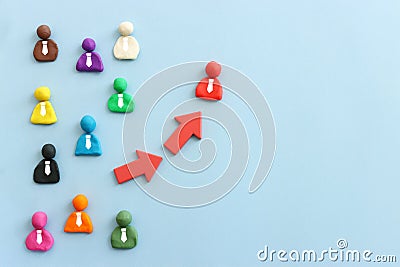 group of figures going in one direction and a unique person heading in a different direction Stock Photo