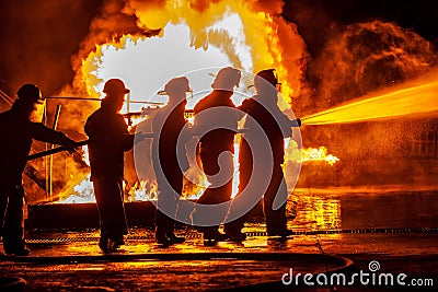 A Group of firefighters moving towards fire with hose Editorial Stock Photo