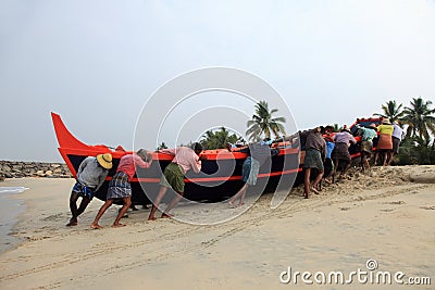 Fishermen work hard to bring the fishing boat to the shore Editorial Stock Photo
