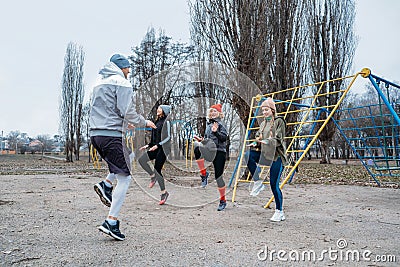 Group fitness workout classes outdoors. Socially Distant Outdoor Workout Classes in public parks. Three women and man Stock Photo