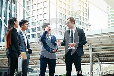 A group of four Asian businessmen Standing meeting for discussions on real estate investment in Asia. Stock Photo
