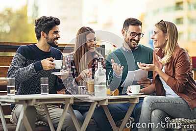 Group of four friends having fun a coffee together. an Stock Photo