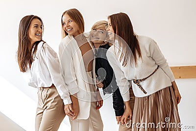 Group of four modern young women friends having fun at the cafe indoors. Stock Photo