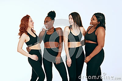 Multiracial females with different size and ethnicity stand together and smile. Stock Photo