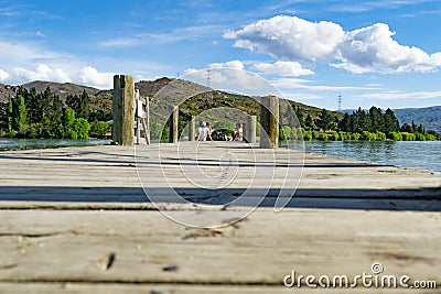 Group four youth sitting on end of pier on Lake Dunstan Editorial Stock Photo