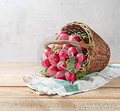Group of fresh radish in a basket on the table. Stock Photo