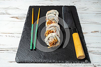 Group of fresh sushi with wooden chopsticks on a black stone plate board and on a white rusty background.Soft focus shot Stock Photo