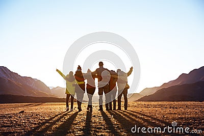 Group of friends against sunset mountains Stock Photo