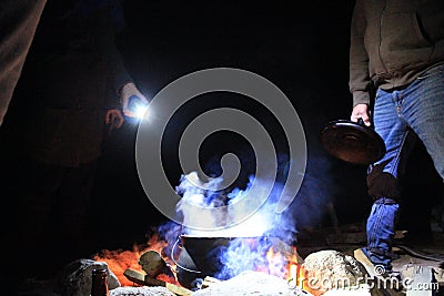 Group of friends cooking outdoors by night, campfire, israel Editorial Stock Photo