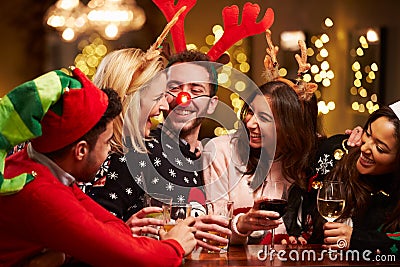 Group Of Friends Enjoying Christmas Drinks In Bar Stock Photo