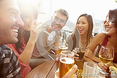 Group Of Friends Enjoying Drink At Outdoor Rooftop Bar Stock Photo