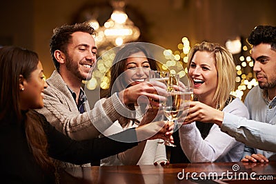 Group Of Friends Enjoying Evening Drinks In Bar Stock Photo