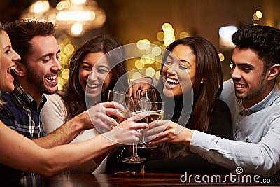 Group Of Friends Enjoying Evening Drinks In Bar Stock Photo