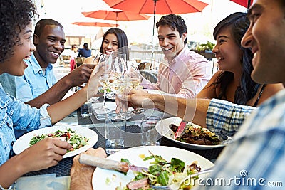 Group Of Friends Enjoying Meal At Outdoor Restaurant Stock Photo