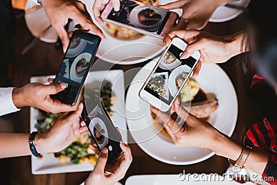 Group of friends going out and taking a photo of Italian food together with mobile phone. Stock Photo