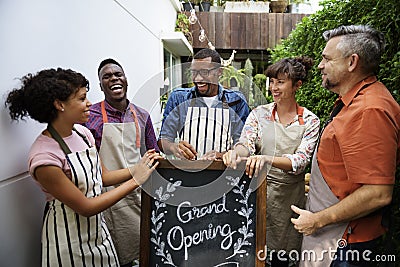 Group of friends with grand opening board together Stock Photo