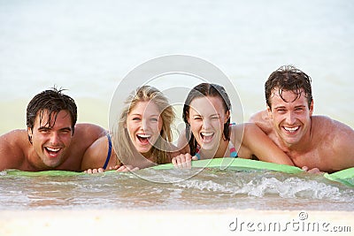 Group Of Friends Having Fun In Sea On Airbed Stock Photo