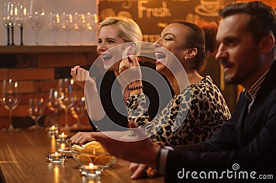 Group of friends having fun talk behind bar counter in a cafe Stock Photo