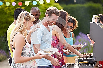 Group Of Friends Having Outdoor Barbeque At Home Stock Photo