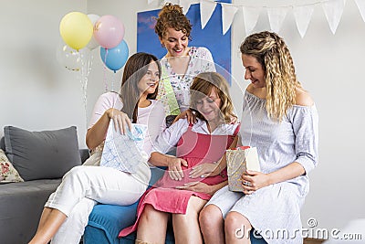 Group of friends in the living room with a baby presents celebrating baby shower Stock Photo
