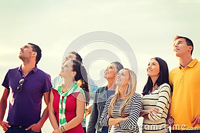 Group of friends looking up on the beach Stock Photo