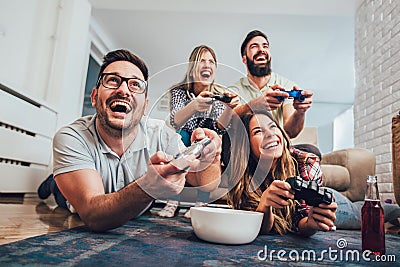 Group of friends play video games together at home Stock Photo