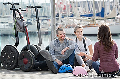 Group of friends posing near segways on shore Stock Photo