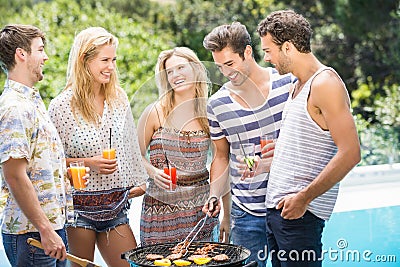 Group of friends preparing barbecue near pool Stock Photo