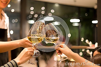 Group of friends raising a toast with glasses of white wine Stock Photo